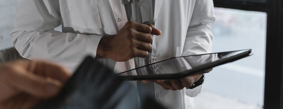 A clinician reviewing patient data on a tablet during a visit.