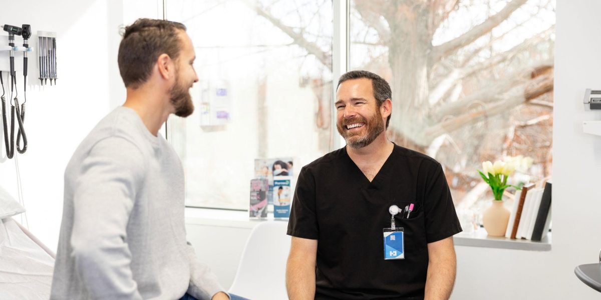 A chiropractor talking with a patient after treatment.
